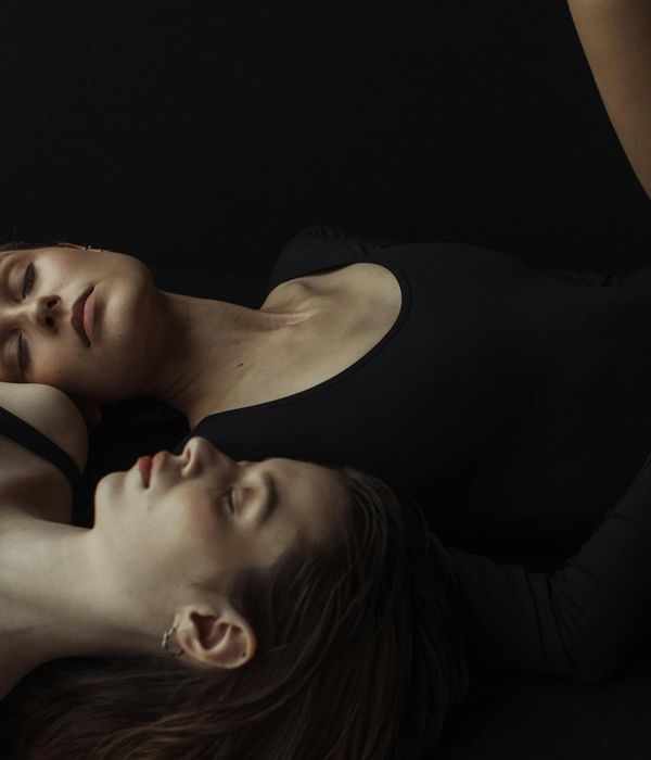 Woman in a calm yoga pose inside a studio with soft lighting.